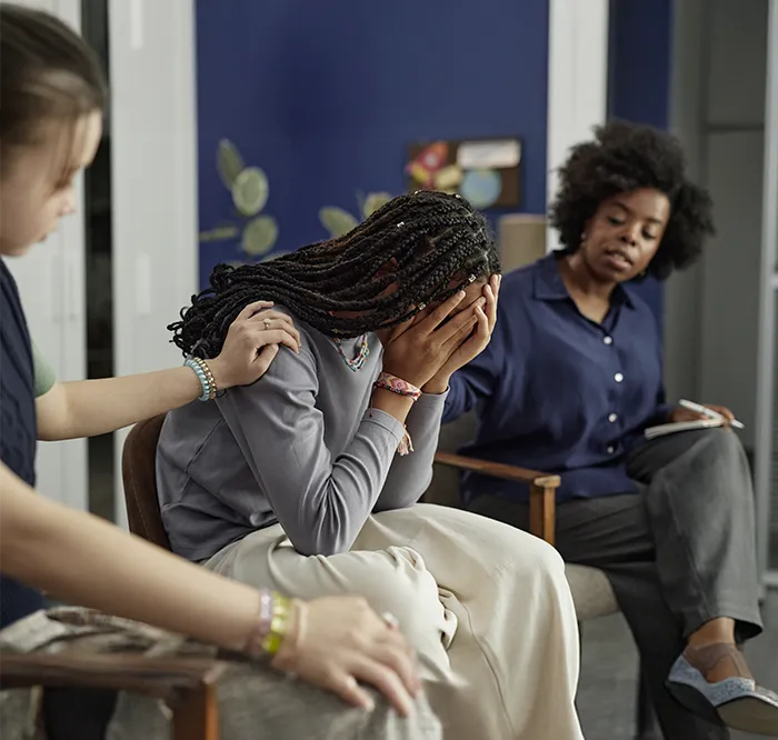 Counselors supporting distressed young woman