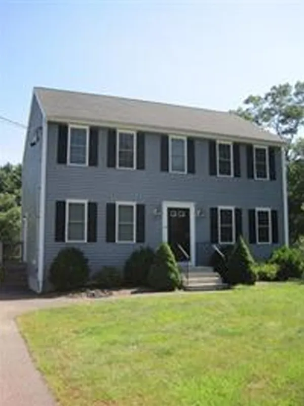 Two-story gray house with black shutters, white trim, and a small front porch.